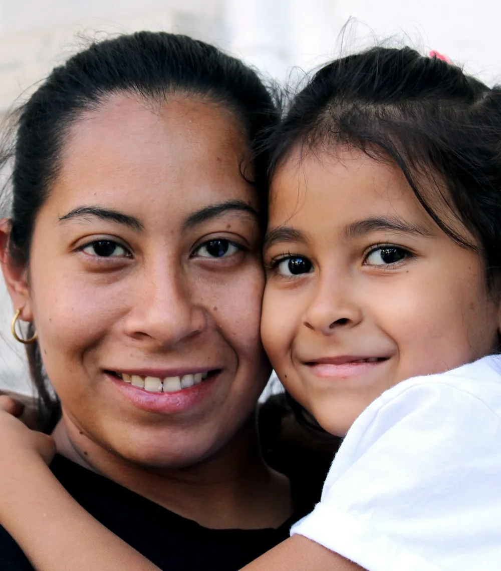 A mother and daughter smiling together